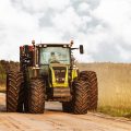 Big tractor on a road at countryside near meadows