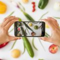 close-up-of-person-taking-photo-of-vegetables-on-white-background