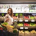 Woman with tablet checking shopping cart to see if she has everything she needs for lunch.